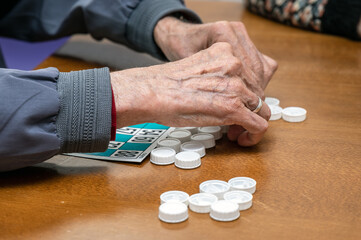 Close up of a senior man playing bingo at Nursing home. leisure game, support, assisted living, and retirement. High quality photo