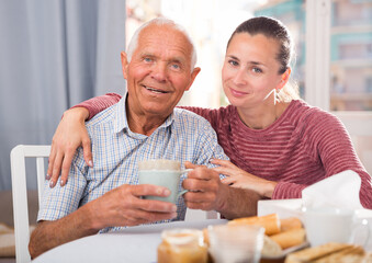 Mature father talks to adult daughter at the table. Tea party. High quality photo