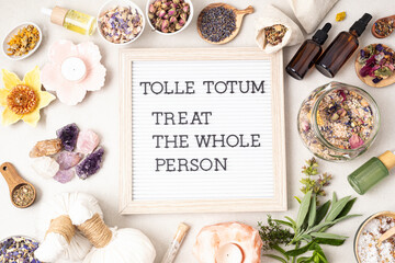 Letter board with text Tolle totum meaning treat the whole person in latin. Naturopatical...