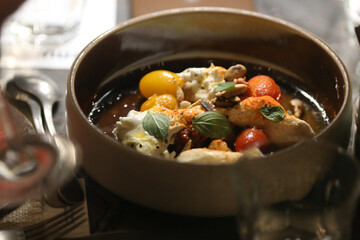  Deliciosa salada com burratas cremosas, suculentos tomates cereja vermelhos e amarelos, crocantes castanhas brasileiras, harmoniosamente decorada com frescas folhas de manjericão.