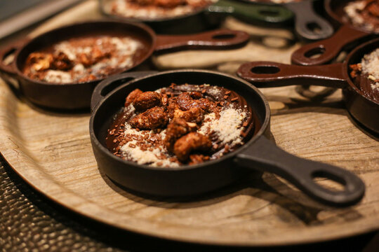 Irresist&iacute;vel ganache de chocolate com crocante de castanhas, delicadamente servidos em charmosas panelinhas de ferro, despertando os sentidos em um evento especial.