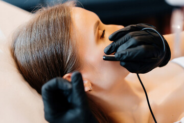 Close up view of doctor is doing electroepilation to the client, using electro needle and tweezers....