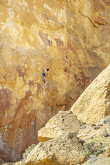 Rock climber hanging on the edge of a rock face