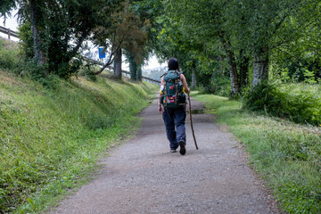 Obraz premium Young woman pilgrim walking on a trail of the way of saint james. Camino de Santiago
