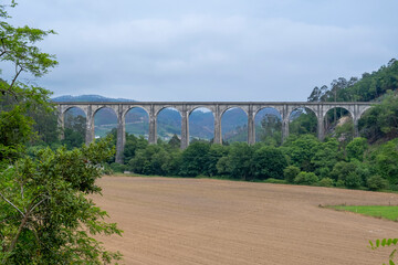 Railway bridge over the Esva river in Asturias, Spain. Cloudy day.