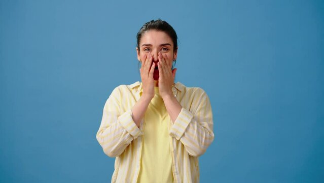 Woman exclaims in surprise and covers mouth with hands