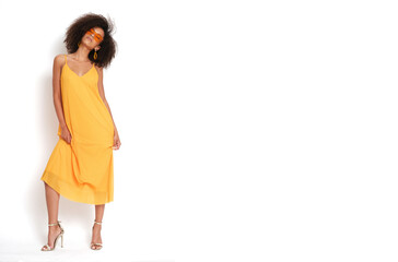 Very attractive young woman with afro hairstyle and yellow dress on isolated white background.