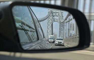 side view mirror view of road with george washington bridge (car, truck, road, traffic, highway)...