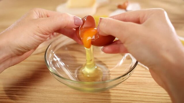 Close up hand breaking an egg to the bowl. Ingredients for focaccia, pie, pizza, ravioli, pasta, bakery, cookbook, cooking blog.