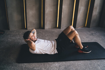 Young man doing exercises on fitness mat