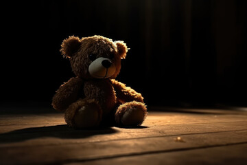 Forgotten teddy bear sitting in the dark abandoned room. Lonely concept. 