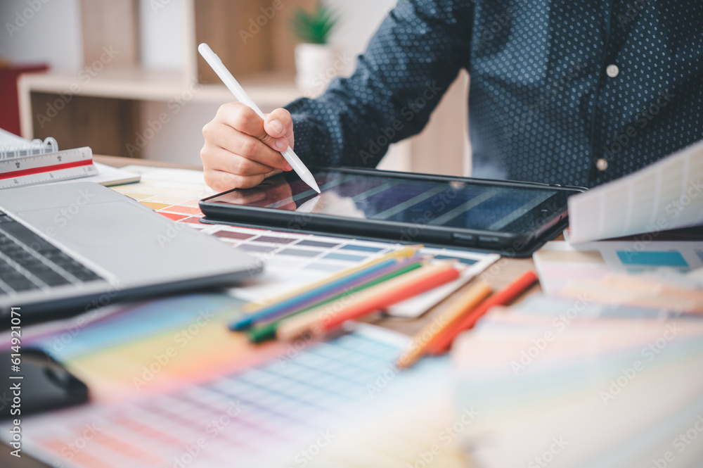 Fototapete Graphic designer architects who work with laptops and color comparison tables for design work..