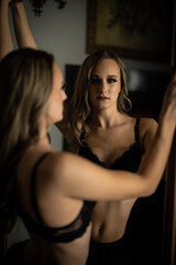 female standing by mirror and fireplace