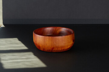 Carved wooden bowl. Dark wood grain dish. Luxury kitchenware.