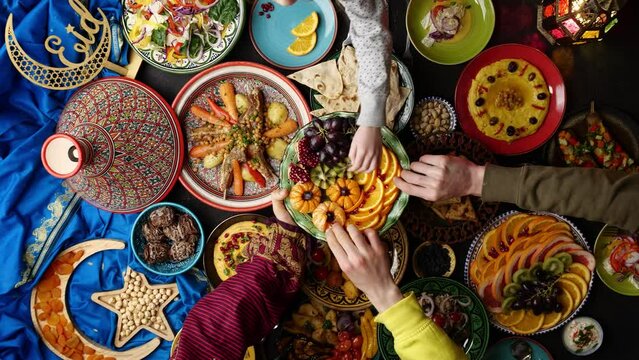 Festive Eid table with authentic traditional Middle Eastern dishes and food top view. Happy Muslim people celebrate the Islamic holiday and eat together