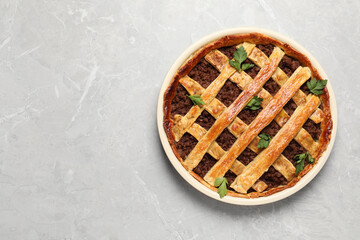 Freshly baked meat pie on light grey table, top view. Space for text