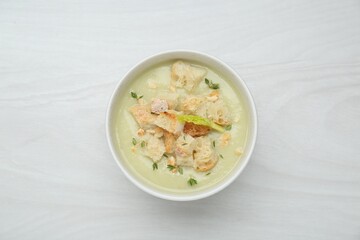 Delicious celery soup on white wooden table, top view
