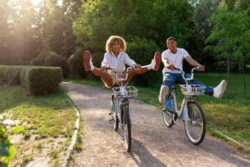 young crazy african american couple ride fast forward bike in park and screaming in amazement