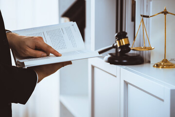 Lawyer or attorney preparing for lawsuit or litigation, reading or studying legal book at bookshelf...