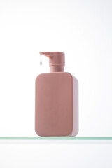 A drop of cosmetics drips from a pink dispenser with a place for your logo. Skin care.