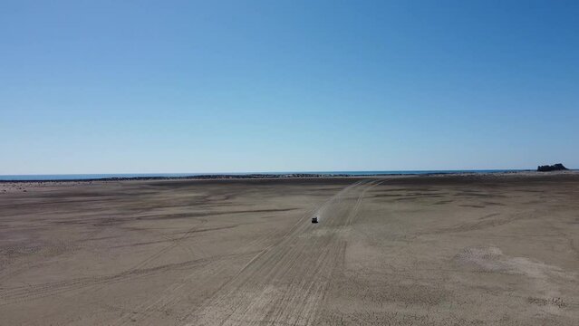 Aerial drone forward moving shot driving along sandy sapat beach, buji koh, Balochistan on a sunny day.
