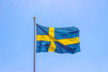 Swedish flag on pole with clear blue sky