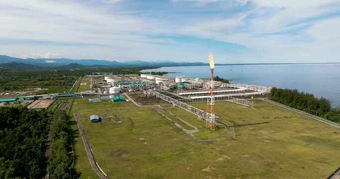 Oil refining factory with constructions and flare stacks. Ground tanks store oil and gas in an oil refinery. Borneo, Sabah, Malaysia.