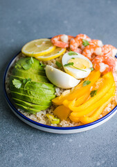 Buddha bowl with avocado, prawns, rice,  on light background. Healthy food, clean eating, Buddha bowl, top view,