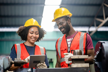 Two African American Mechanical Engineers using a digital tablet and discussing workshop machine maintenance in a factory, exam, inspection, training, Working together, teamwork concept.