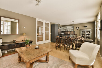 a living room and kitchen area in a house with wood floors, white walls, hardwood flooring and large windows