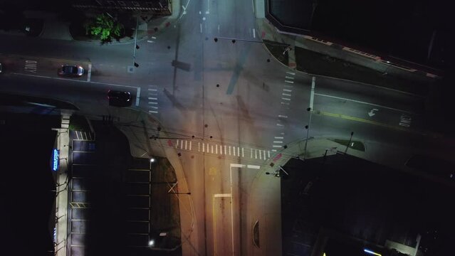 top down tracking cinematic nightshot aerial of a car driving on streets of old american town illuminated by street lights.  Marengo Illinois, USA Blured logo.