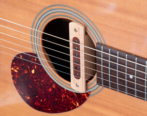 cloise up shot of acoustic guitar sound hole pickup type . made by wood, selective focus