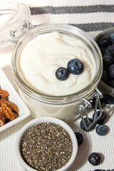 Glass jar with natural organic homemade yogurt and blueberries pecan nut chia seeds pudding. Immunity-boosting ingredients. Concept of healthy eating breakfast of Greek yogurt in glass jar and fresh