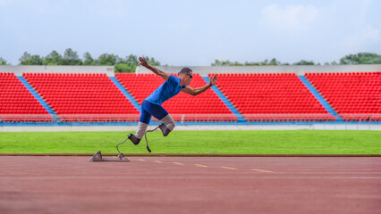 Asian male athlete, prosthetics user, sprints off from block start, powering his practice run on...