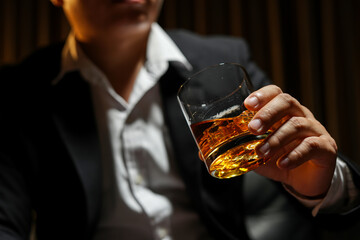 Closeup businessmen holding a glass of whiskey