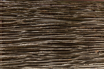 Fence made of dry brown rods. Background, space for text. Close-up.