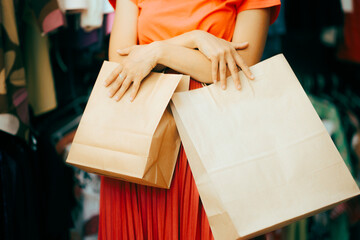 Detail of Hands Holding Eco Friendly Paper Shopping Bags. Lady on a shopping spree buying from clothing store
