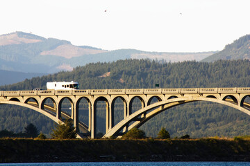 Bridge Over Rogue River Oregon With Hills And Sky