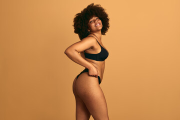 Alluring black woman in underwear looking at camera