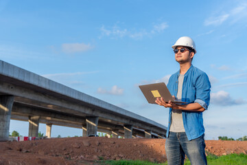 Architects using laptop at road construction site.