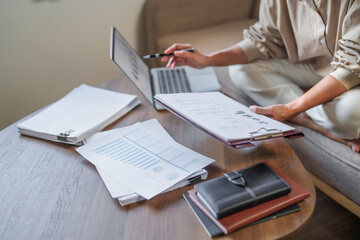 Female calculating personal financial for future plan at her home, taxes payment..