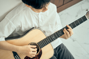 young male musician playing acoustic guitar , Close up classic guitar , finger style . happy mood...