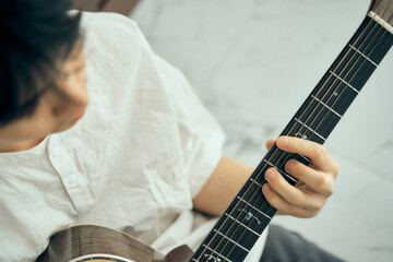 young male musician playing acoustic guitar , Close up classic guitar , finger style . happy mood...