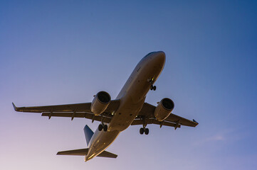 Fototapeta na wymiar Bottom view of a flying plane against a blue sky. 
