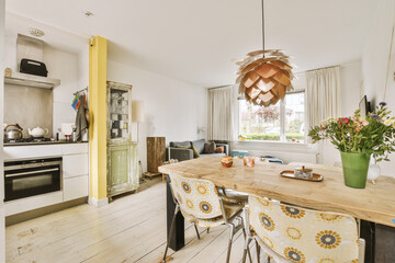 a kitchen and dining area in a house with white walls, wood flooring and yellow curtains on the windows
