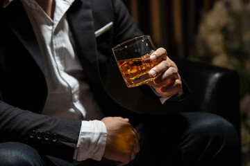 Businessman sitting Holding a Glass of Whiskey Drink Whiskey in the liquor store room