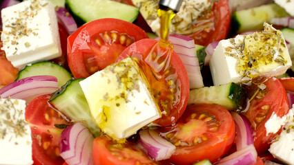Pouring olive oil on greek salad. Fresh vegetable salad, mediterranean cuisine