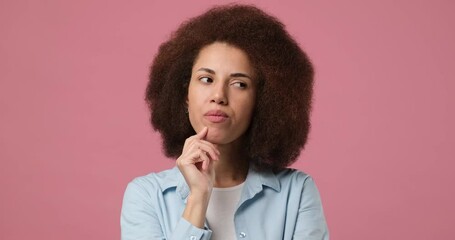 young curly arican american woman thinking and smiling standing over pink studio background