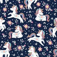 White unicorn with rainbow mane and tail. Vector seamless pattern with cute unicorns on dark floral background © Nataliia