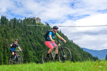 Zwei Mountainbiker vor der Burgruine Ehrenbergbei Reutte  in Tirol